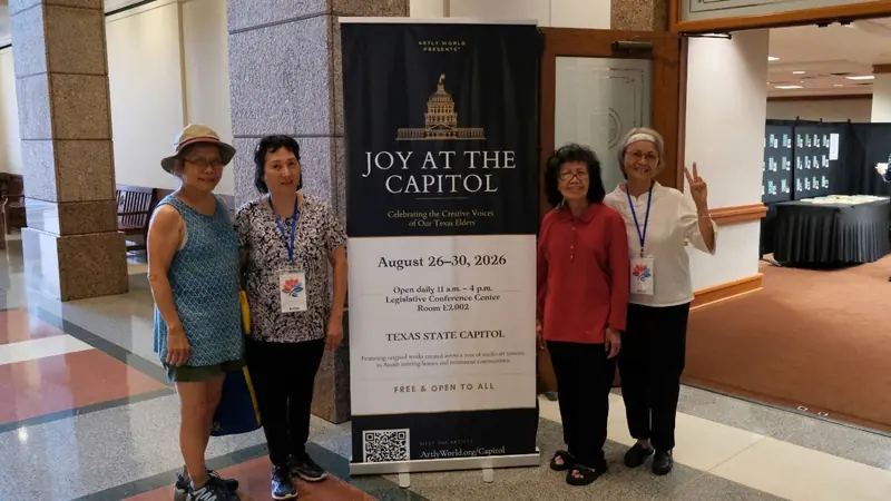 Four senior artists stand on either side of the exhibition banner.