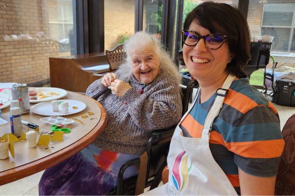 A volunteer setting up brushes and paper before an Artly World session.